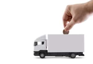 Moeda entrando no caminhão representa o custo do transporte no e-commerce.