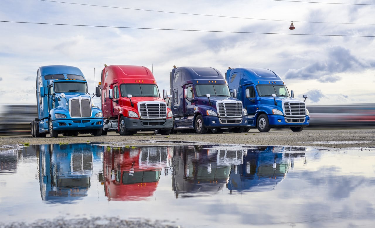 Imagem com quatro veículos mostra como escolher o caminhão ideal para frete.