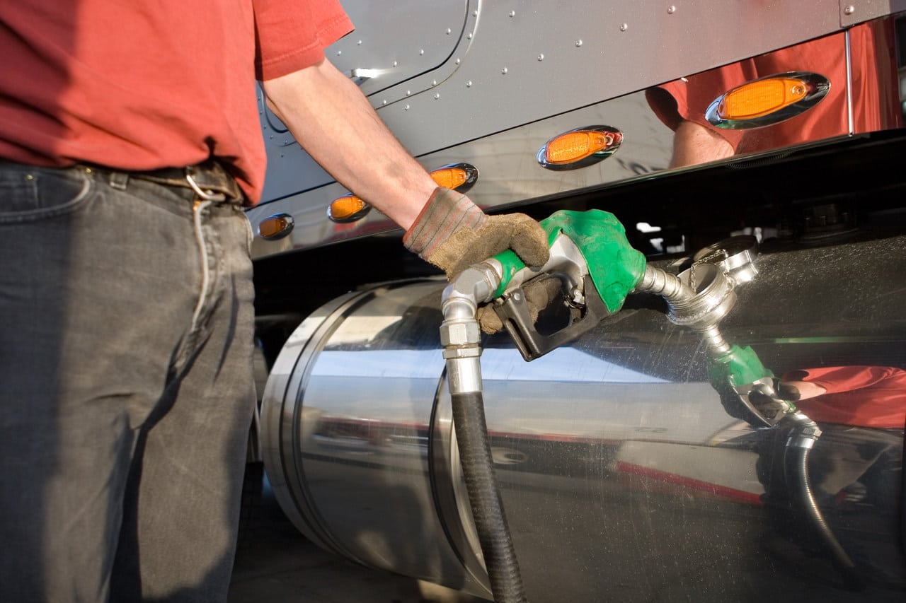 Frentista abastecendo caminhão ilustra como economizar combustível.