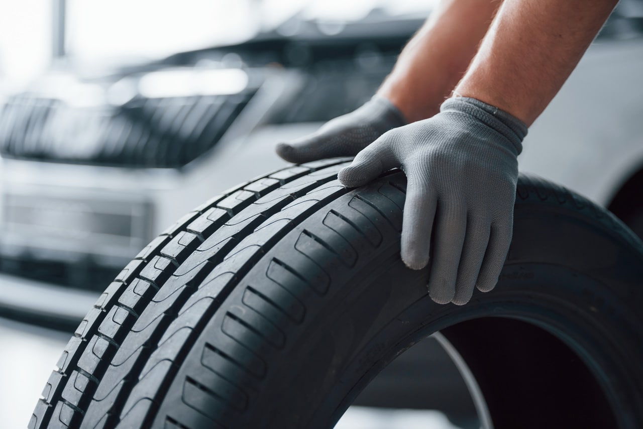 Imagem de mãos segurando um pneu representando a gestão de pneus.